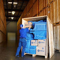 Hilldrup employee stacking boxes into storage crate