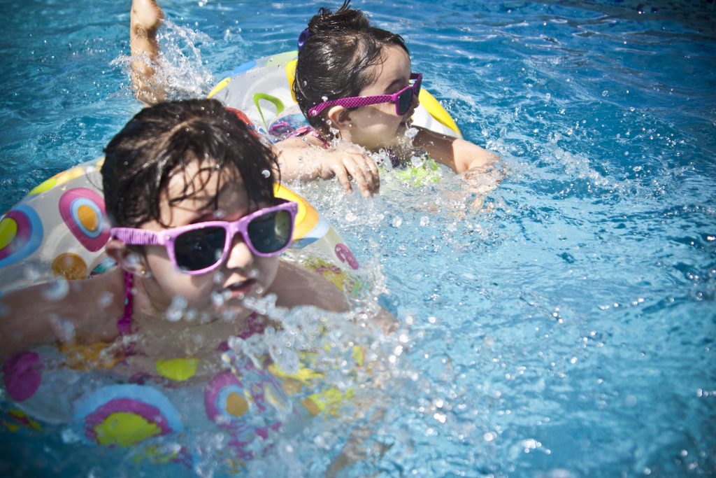 Children swimming with sunglasses on