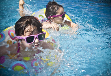Children swimming with sunglasses on