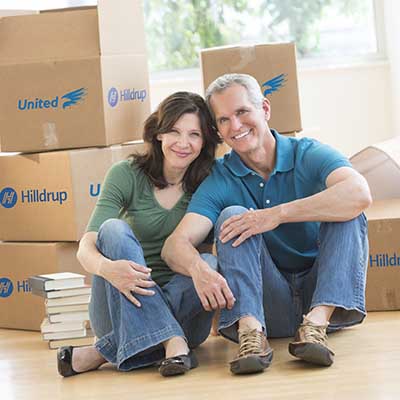 Empty nesters with moving boxes behind them