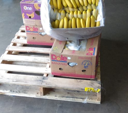 Boxes of bananas sitting on a pallet in a warehouse