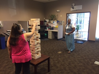 Hilldrup Orlando branch employees playing life-size Jenga during a Wednesday Wake-Up morning activity