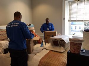 Movers pack items in a bedroom