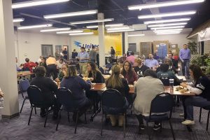 Employees enjoy a potluck wearing jerseys for the superbowl