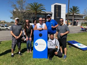 Hilldrup employees with Hilldrup cornhole board