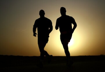 Two men running at sunrise