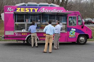 Employees wait for food from Zesty Adventure food truck