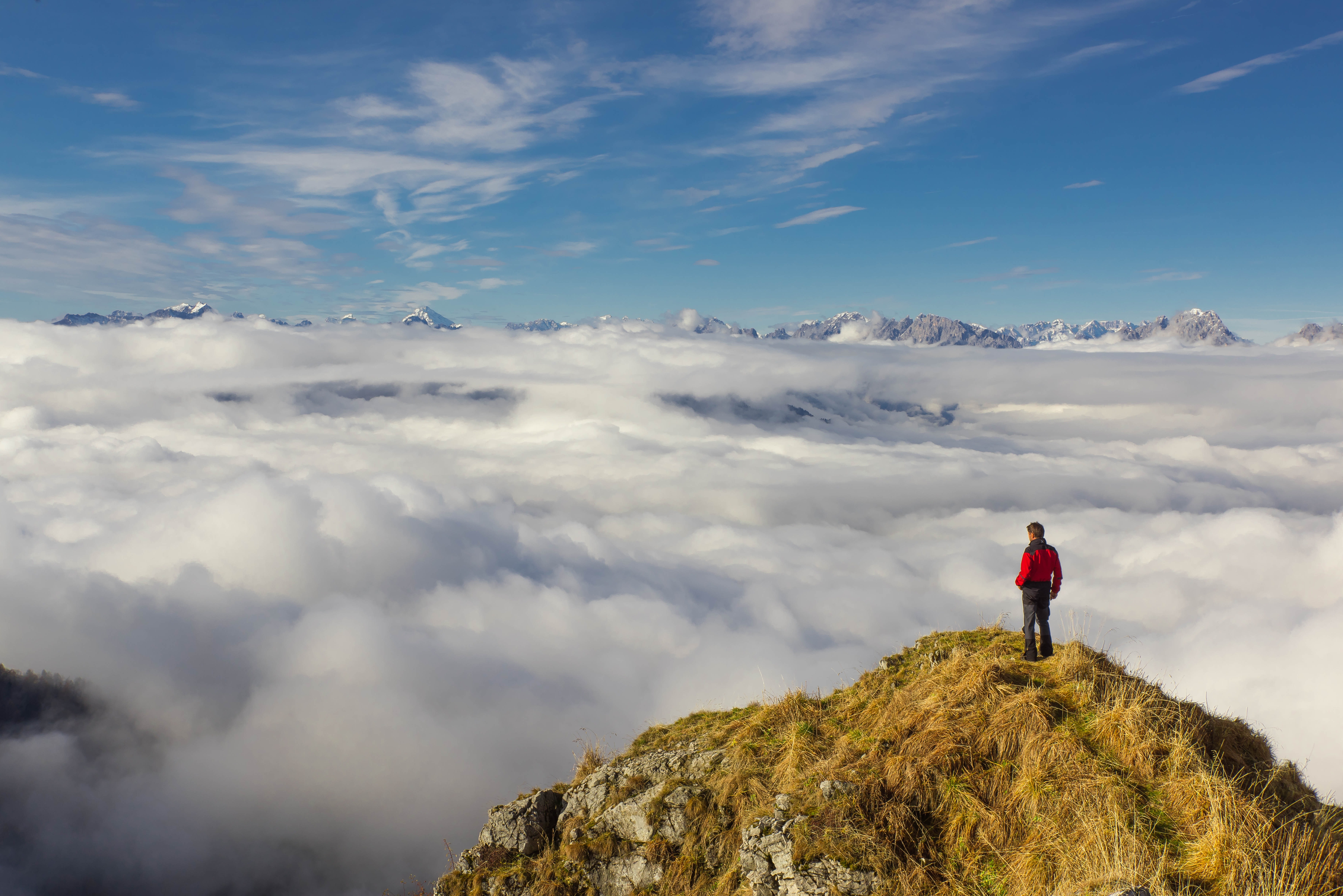 Man atop a mountain looking across landscape