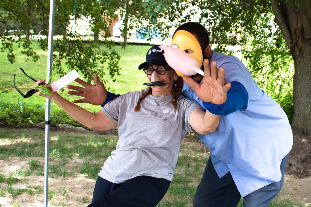 Hilldrup employees wearing props to snap a photo at the photo booth