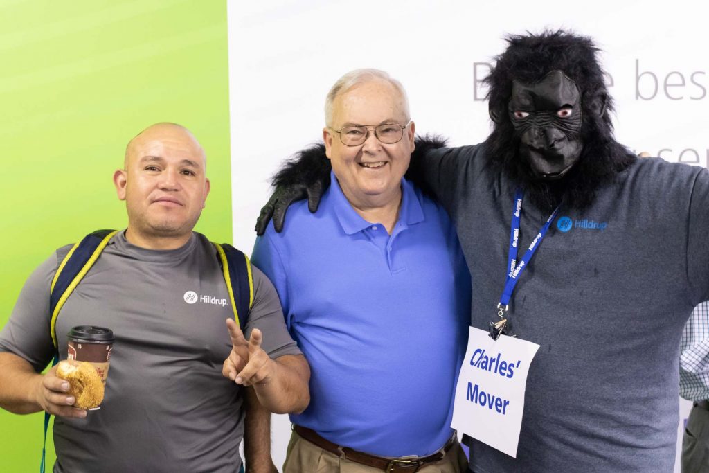 Melvin Funes, Barry Dodson, and Tom Hinkley dressed in a gorilla suit posing for a picture