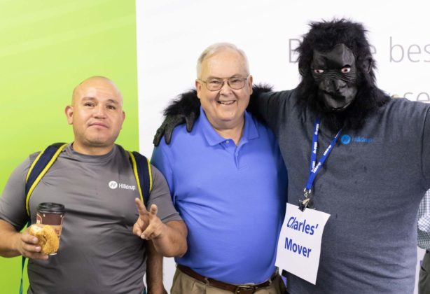 Melvin Funes, Barry Dodson, and Tom Hinkley dressed in a gorilla suit posing for a picture