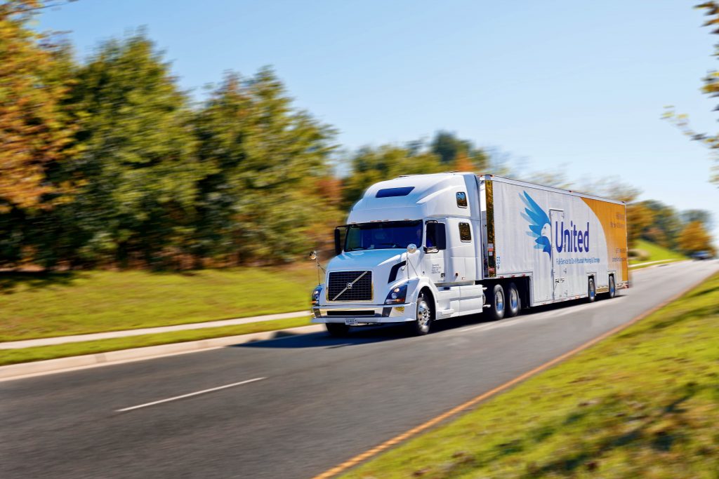 Hilldrup moving truck in motion on a backroad