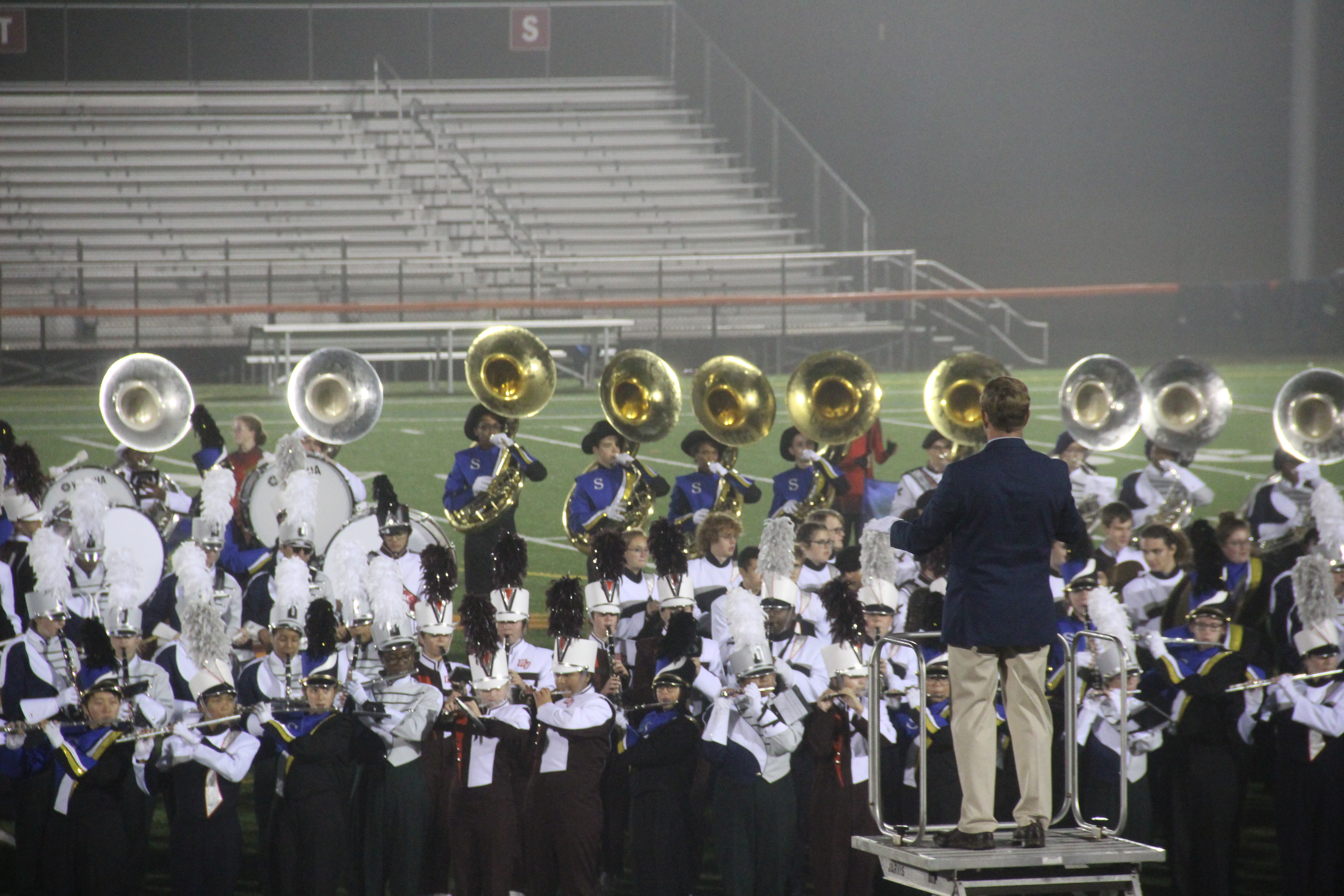 John Lohmeyer with band students and check with donated amount