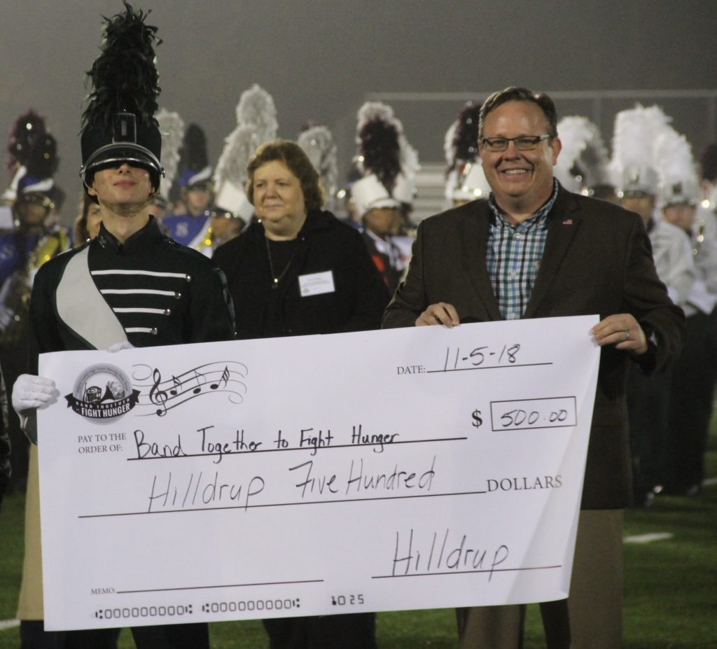 John Lohmeyer with band students and check with donated amount