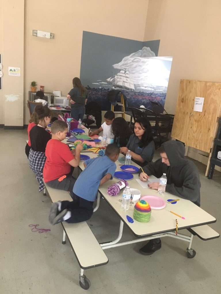 Children at the homeless shelter enjoy crafts together at a table