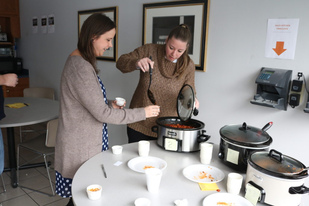 Hilldrup employee pours chili in cup for another employee