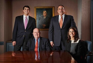 Charlie, Charles G., Charles W., and Jordan McDaniel posing in a conference room