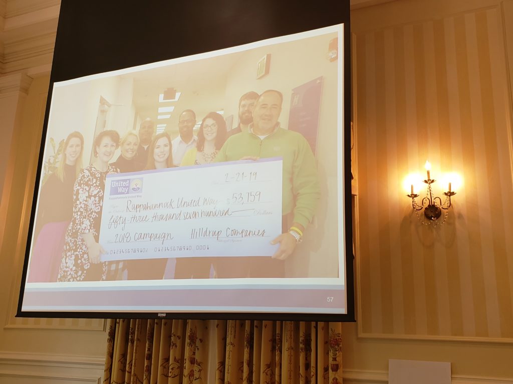 A powerpoint slide showing Hilldrup Stafford employees with our check of money raised throughout the campaign.