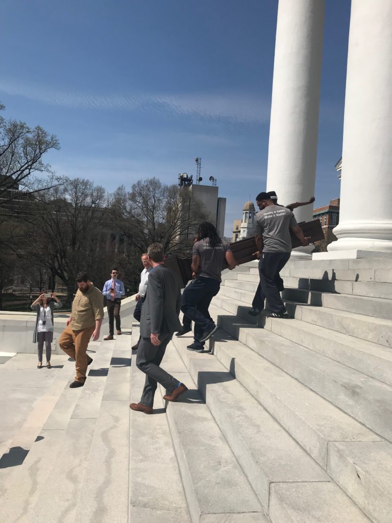 Hilldrup movers carefully carrying the Virginia relic down the stairs