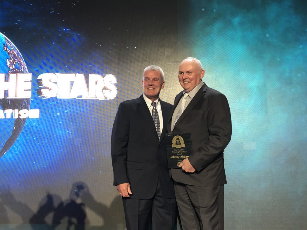 Johnny Abbott and Randy Rantz posing for a photo with award