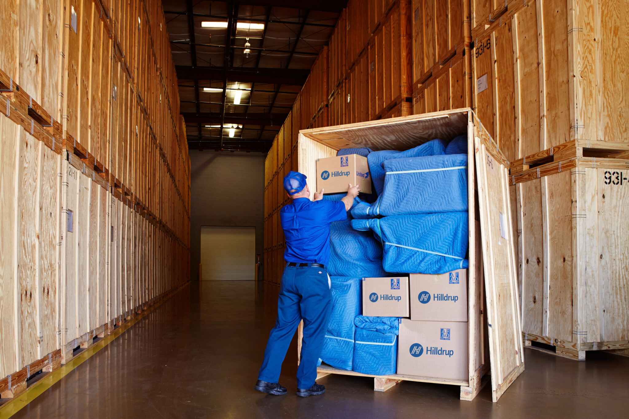 Hilldrup employee stacking boxes in storage crate