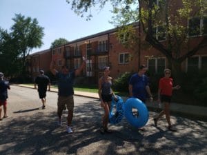 Participants of the SLIDEFXBG event walk back up the hill to slide again