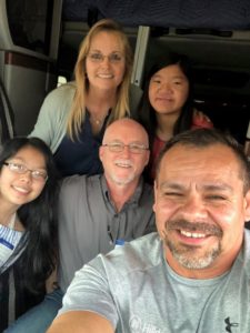 A family takes a selfie with a Hilldrup driver