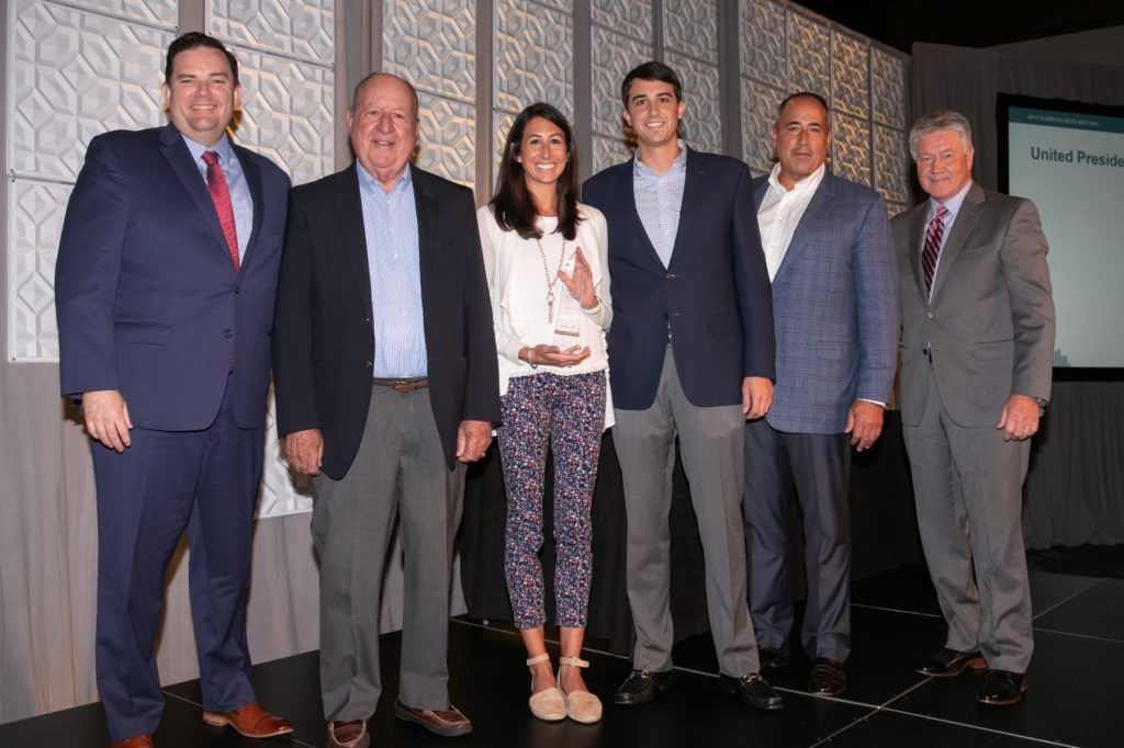 The McDaniel family is photographed with Marc Rogers and Barry Vaughn and the President's Club Award