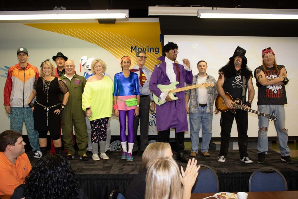 senior leadership group dressed in 80s gear for Halloween