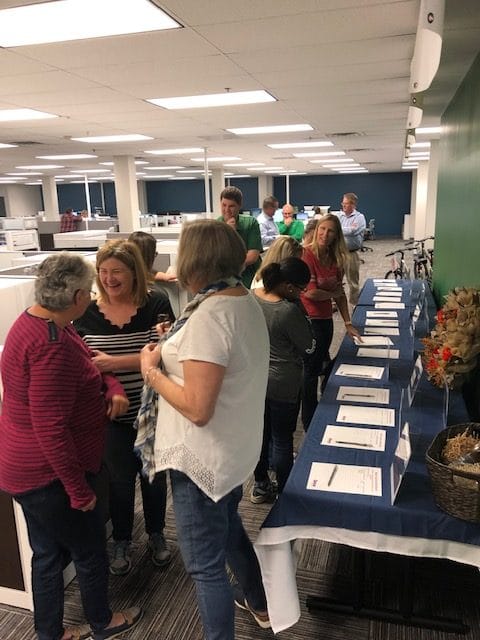 employees gathered around silent auction items for fundraiser for Rappahannock United Way