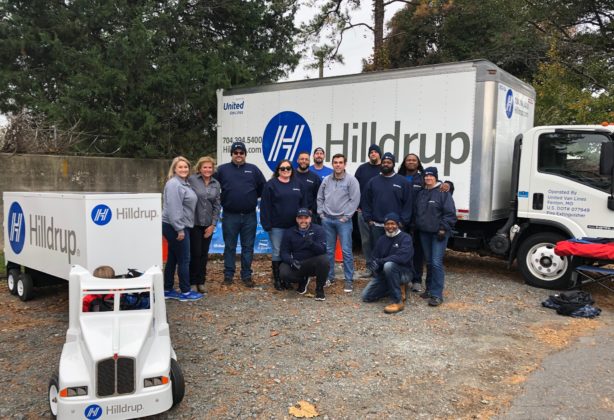 Hilldrup office employees and service team members gather for a photo next to a Hilldrup truck..