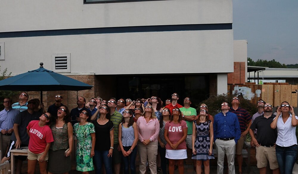 Hilldrup employees watching the solar eclipse in August 2017 with their solar eclipse glasses to protect their eyes