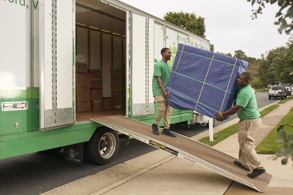 Two guys moving furniture onto a truck