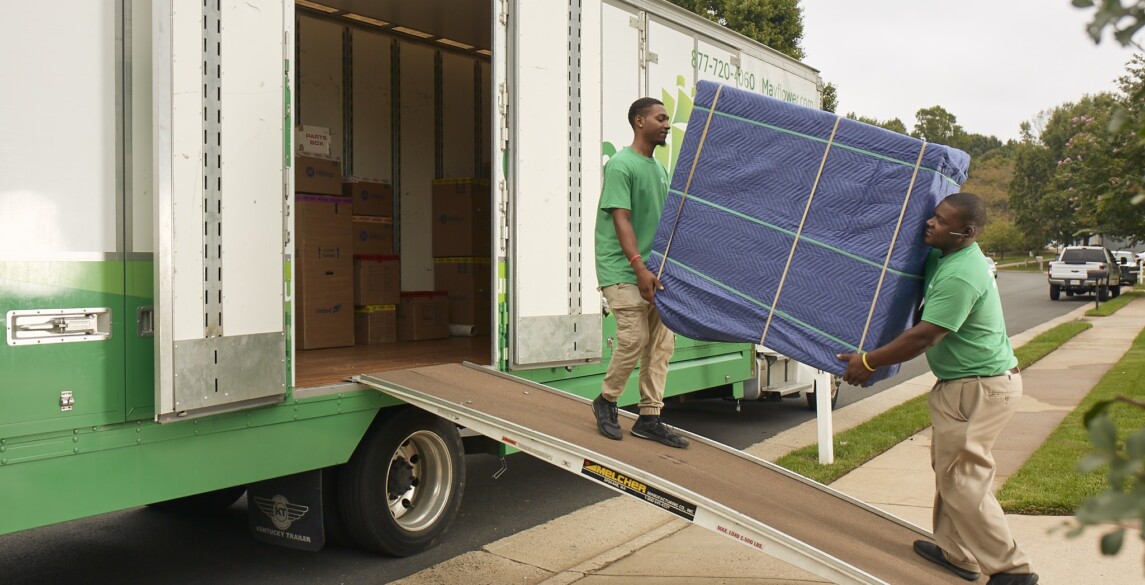 Two guys moving furniture onto a truck