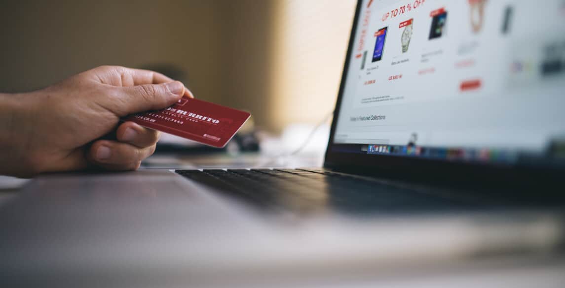 Person sitting at computer about to buy something with their credit card