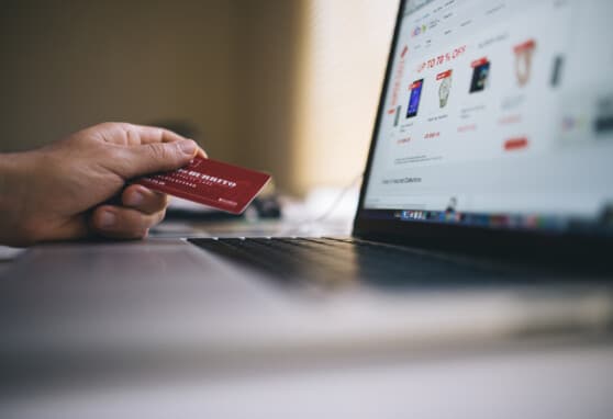Person sitting at computer about to buy something with their credit card