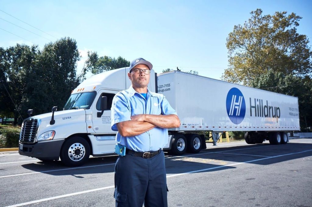 Fred Minor, Hilldrup Van Operator, stands besides a Hilldrup tractor trailer.