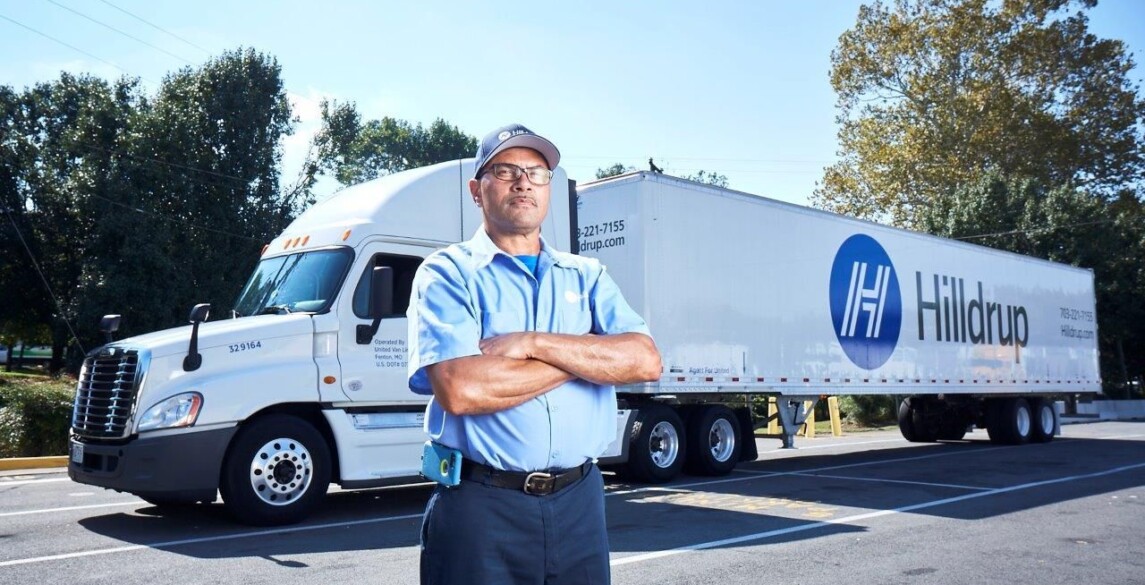 Fred Minor, Hilldrup Van Operator, stands besides a Hilldrup tractor trailer.