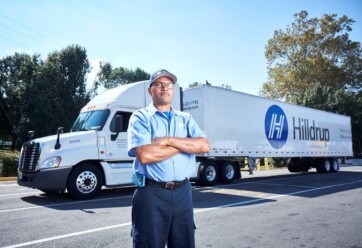 Fred Minor, Hilldrup Van Operator, stands besides a Hilldrup tractor trailer.