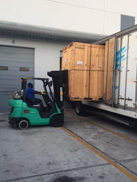 Hilldrup Orlando places a crate into a truck.