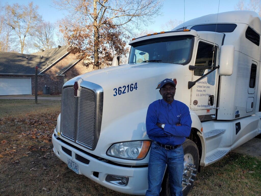 Olu, Stafford Van Operator, stands by his truck.
