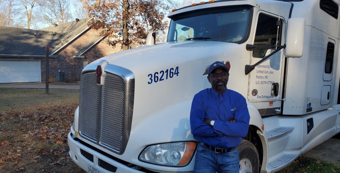 Olu, Stafford Van Operator, stands by his truck.