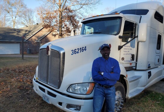 Olu, Stafford Van Operator, stands by his truck.