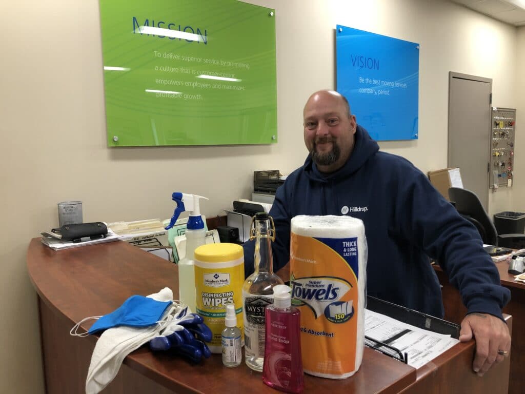 Hilldrup team members with cleaning supplies in the office. 