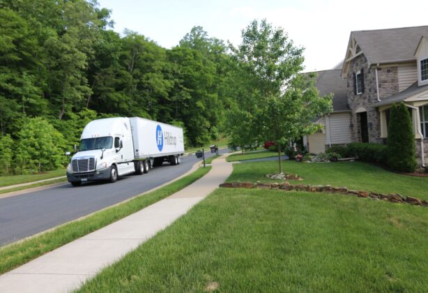 Hilldrup truck driving through a residential neighborhood.