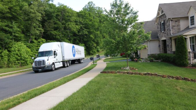 Hilldrup truck driving through a residential neighborhood.