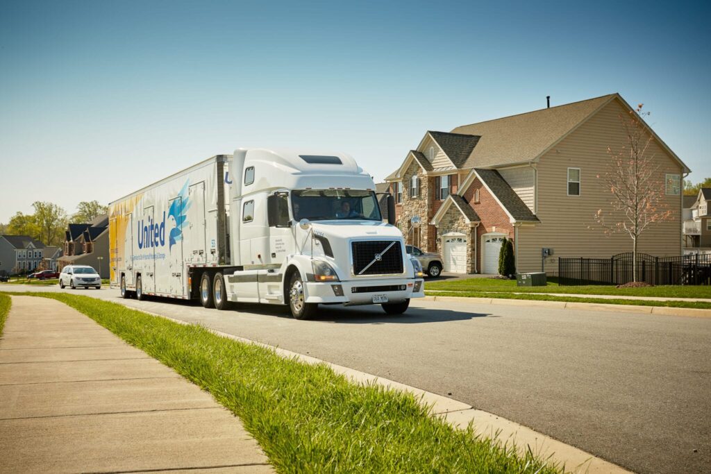 Hilldrup truck driving through a neighborhood.