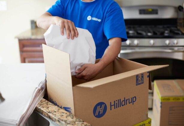 Hilldrup employee packing wrapped items in a kitchen.