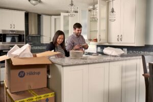 Couple unpacking items in their kitchen.