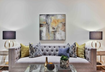 Picture of a living room with a couch, coffee table, side tables, lamps and a painting.